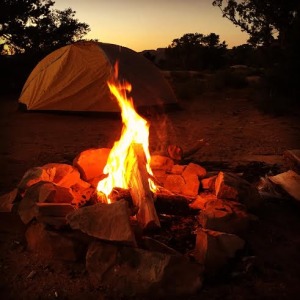 campfire with yellow tent in the background