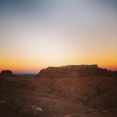 sun setting over red rocks in goblin valley state park