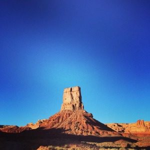 red butte in the middle of a vast desert